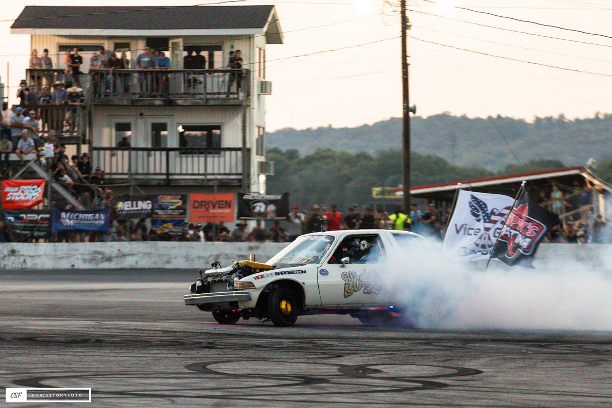 Pit Boss AMC Pacer doing a burnout in the burnout pit, with tire smoke and a crowd watching