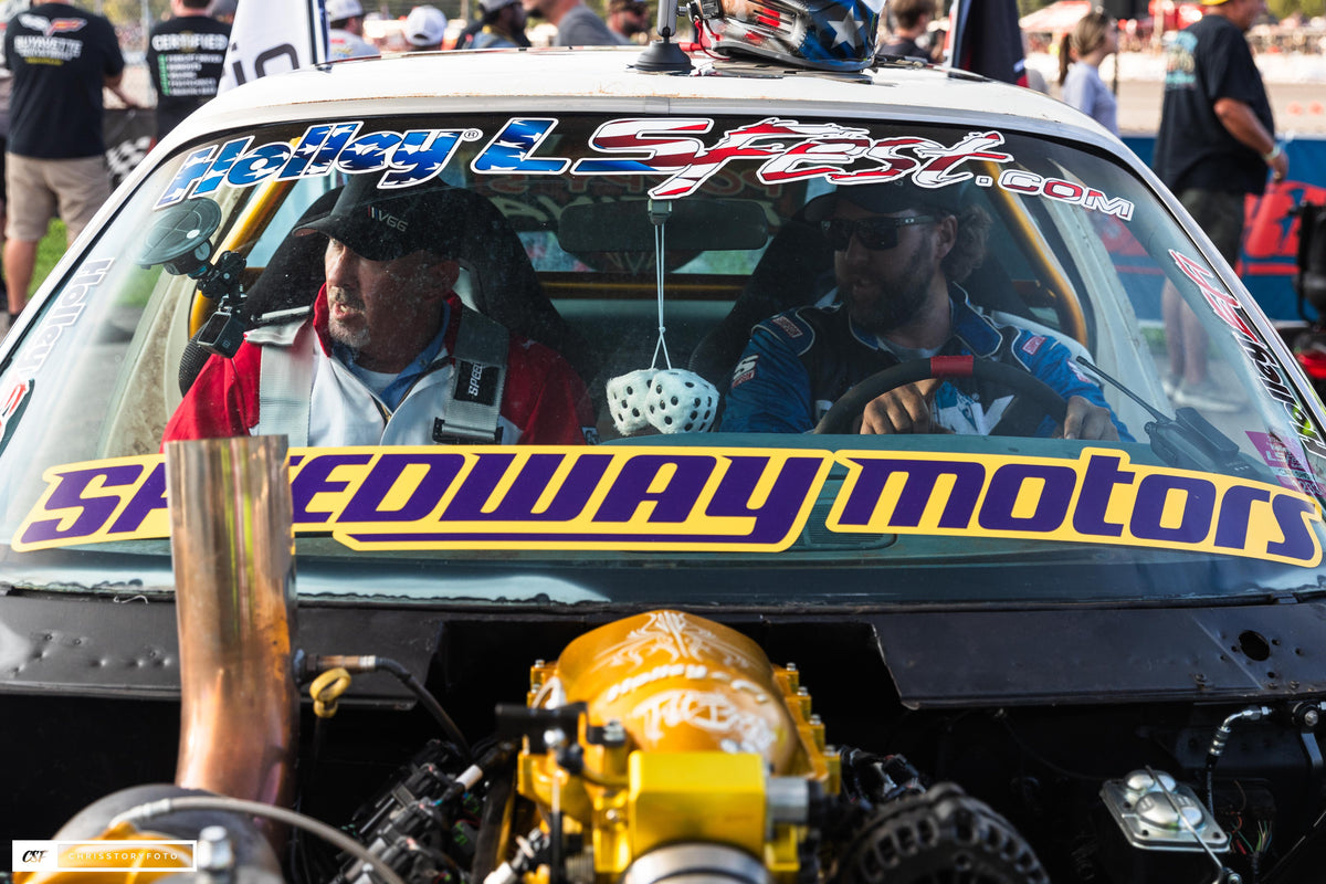 Windshield view of Pit Boss with a Speedway Motors banner and the gold intake